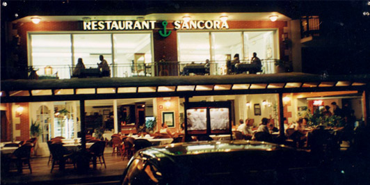 Photograph of the facade of the restaurant at night